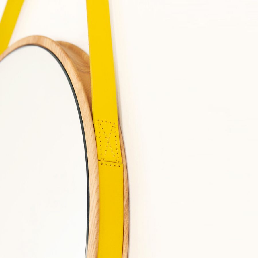 Round wooden mirror with yellow leather strap